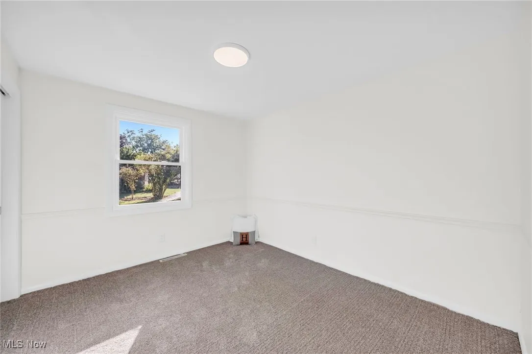 Carpeted empty room featuring baseboards