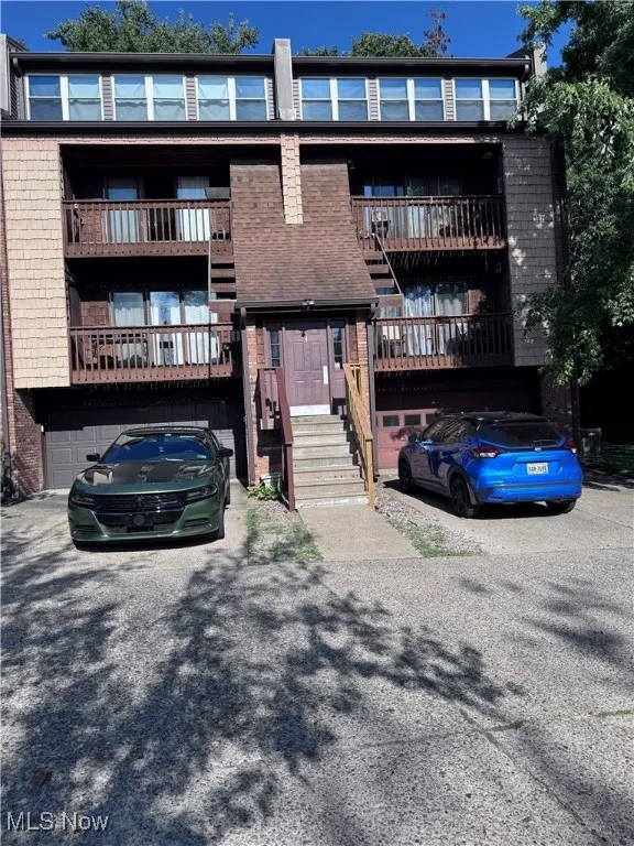 View of building exterior featuring a garage and asphalt driveway