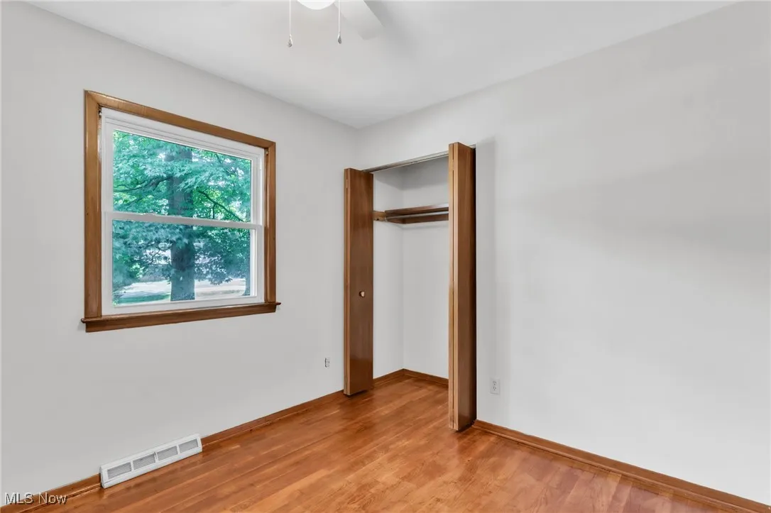 Unfurnished bedroom featuring light wood finished floors, a closet, and ceiling fan