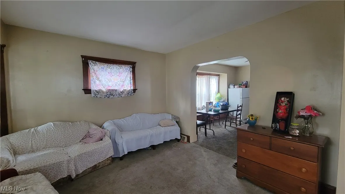 Sitting room with carpet flooring and arched walkways