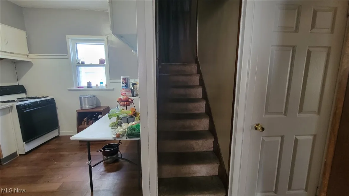 Stairway with wood finished floors and baseboards leading from foyer to 2nd floor