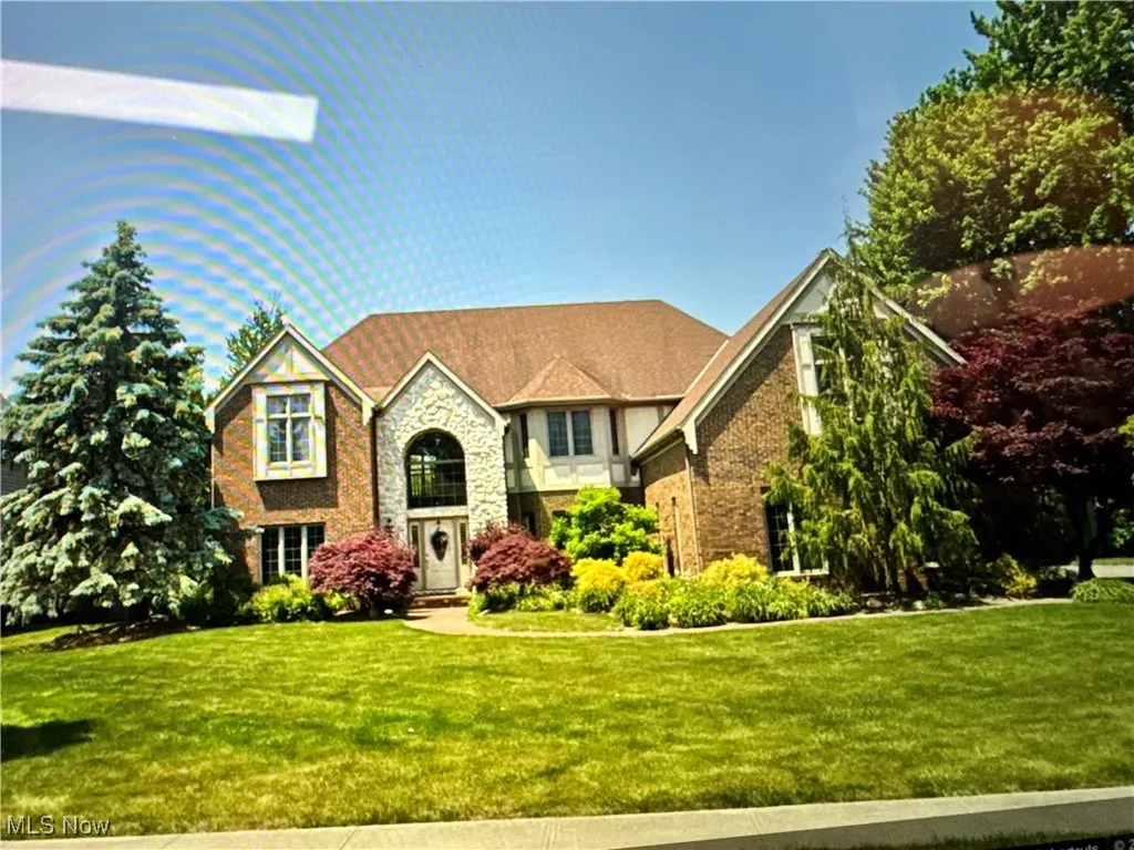 Tudor-style house with a front yard and stone siding