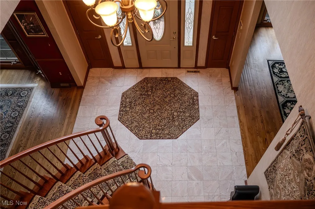 Entryway with a chandelier, light wood finished floors, and stairway