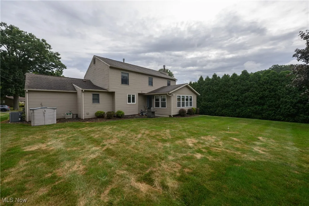 Back of property with a yard and an attached garage