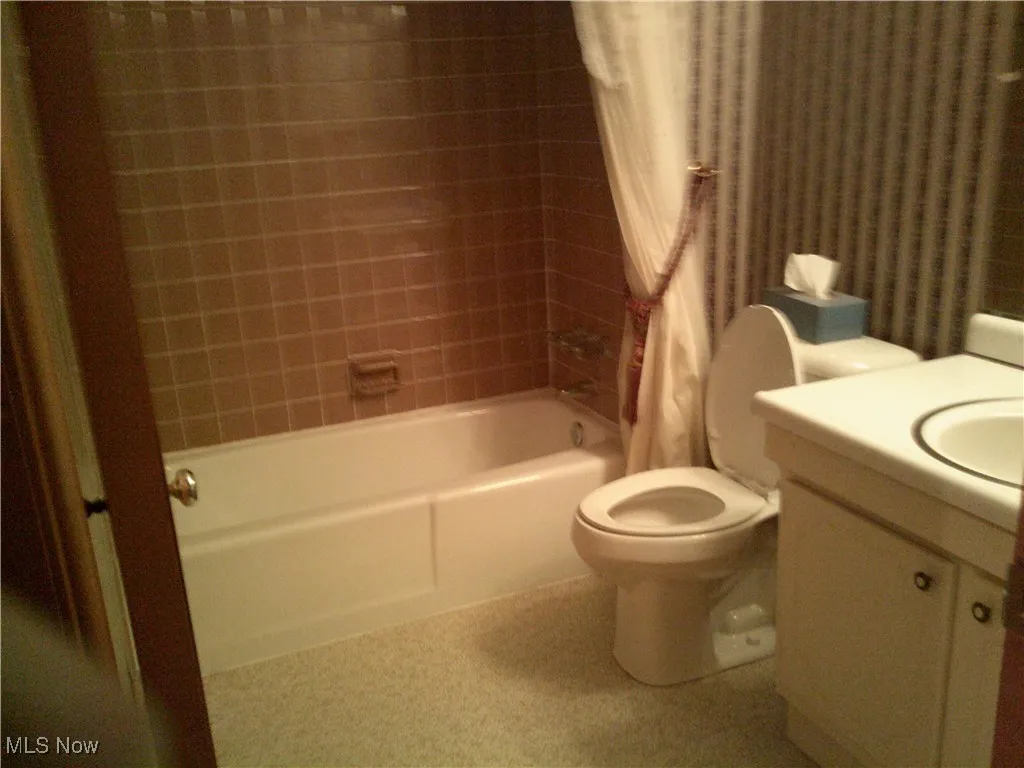 Bathroom with shower / bath combo with shower curtain and vanity