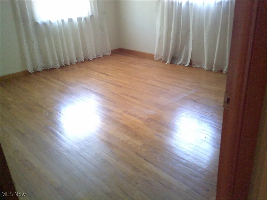 Empty room with light wood-style floors and baseboards