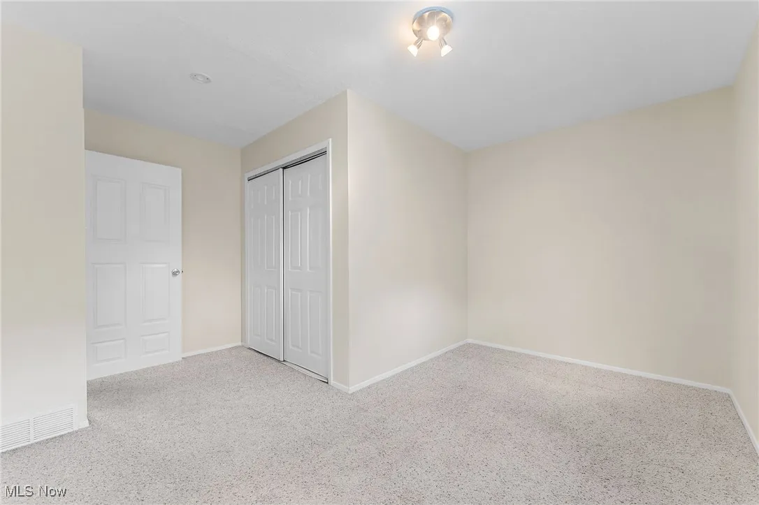 Unfurnished bedroom featuring a closet and carpet floors