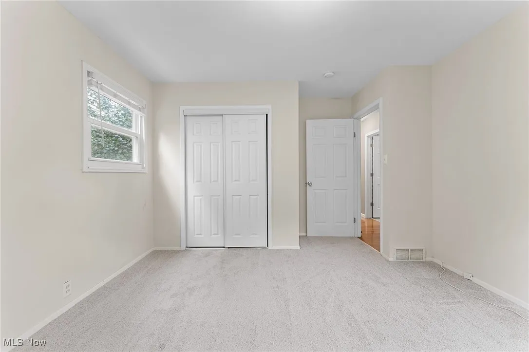 Unfurnished bedroom featuring light colored carpet and a closet