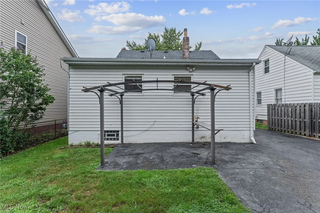 Back of house with a chimney, a patio area, roof with shingles, and a pergola
