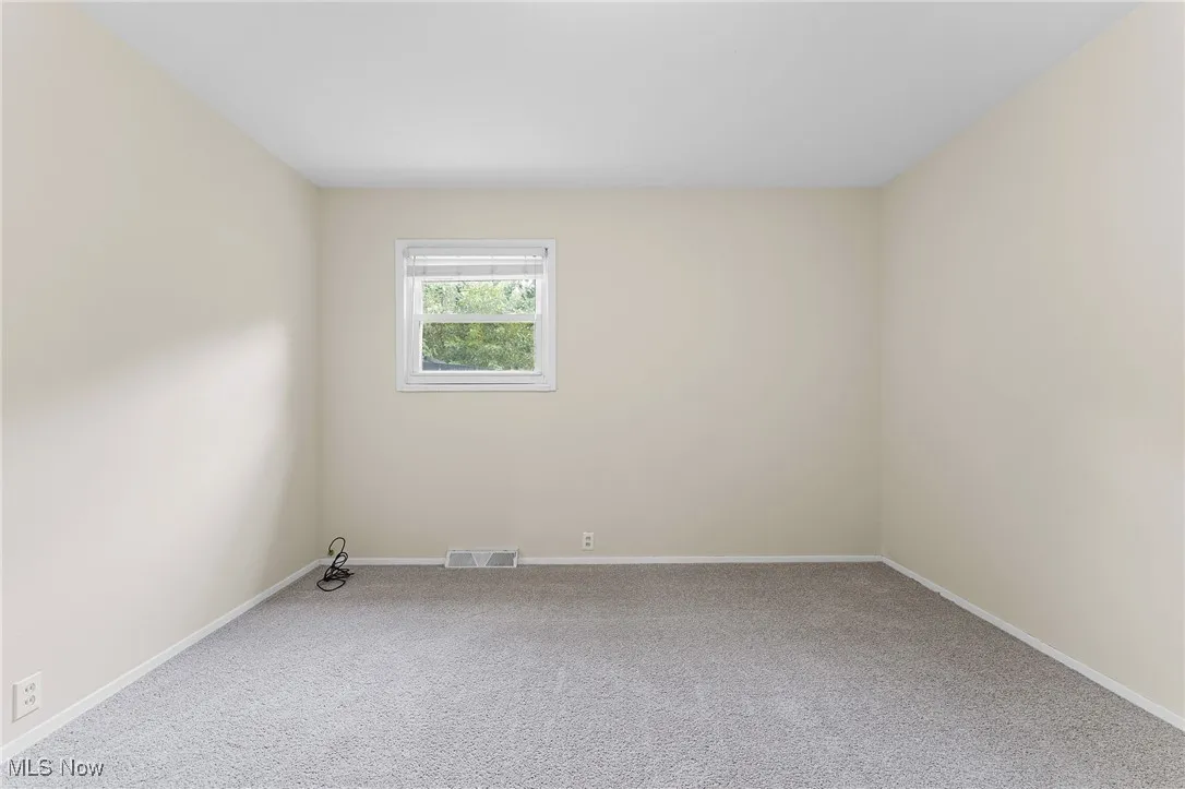 Unfurnished room featuring carpet and baseboards