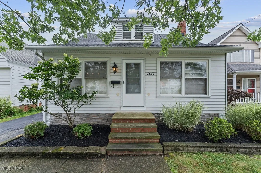 Bungalow-style home with a chimney, roof with shingles, and entry steps
