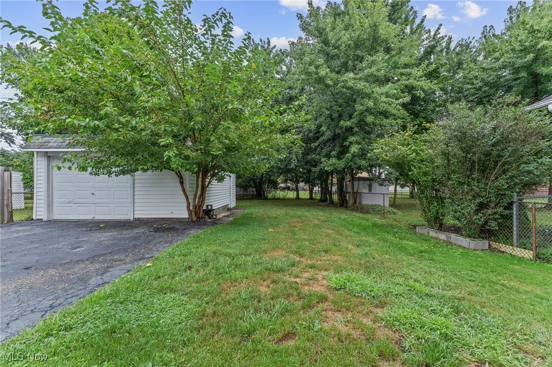 View of yard featuring asphalt driveway and an outbuilding