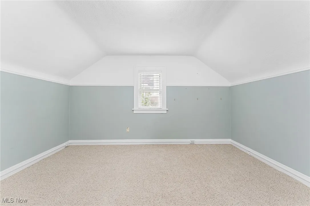 Bonus room with vaulted ceiling, carpet, and a textured ceiling
