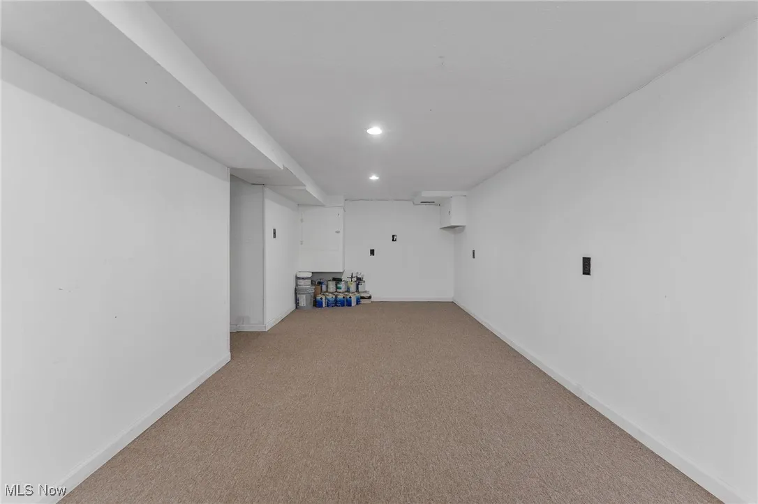 Finished basement with light carpet and recessed lighting