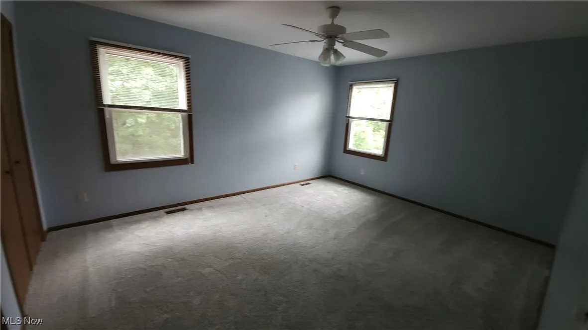 Empty room with carpet flooring and ceiling fan