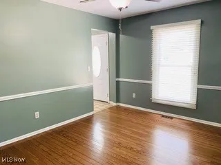 Spare room with wood finished floors and ceiling fan