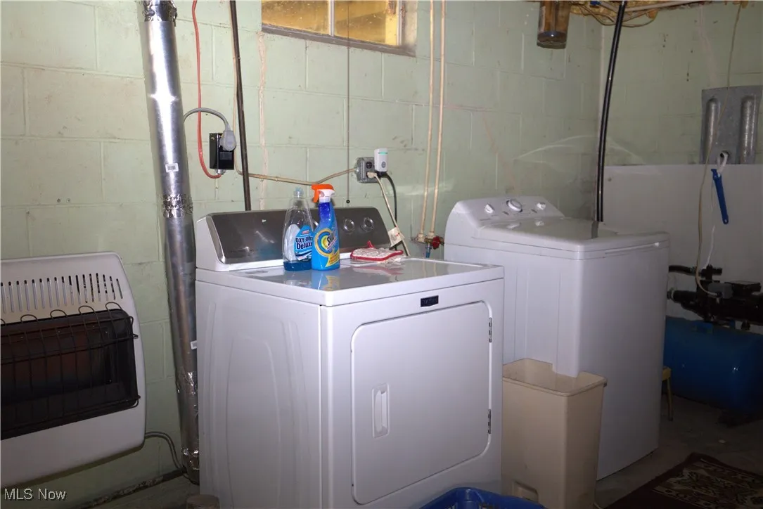 Laundry room featuring heating unit and separate washer and dryer