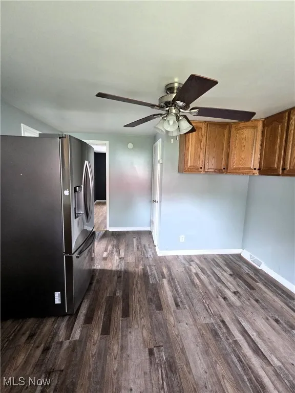 Unfurnished living room with dark wood-type flooring and ceiling fan