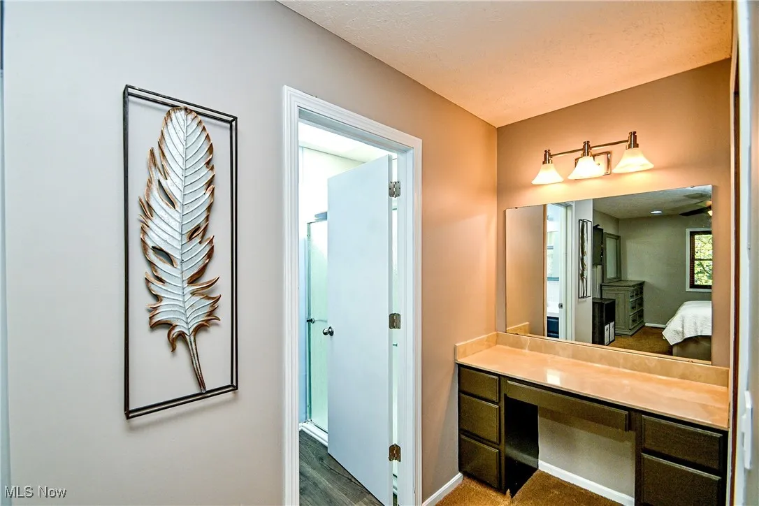 Ensuite bathroom with wood finished floors, a textured ceiling, and vanity