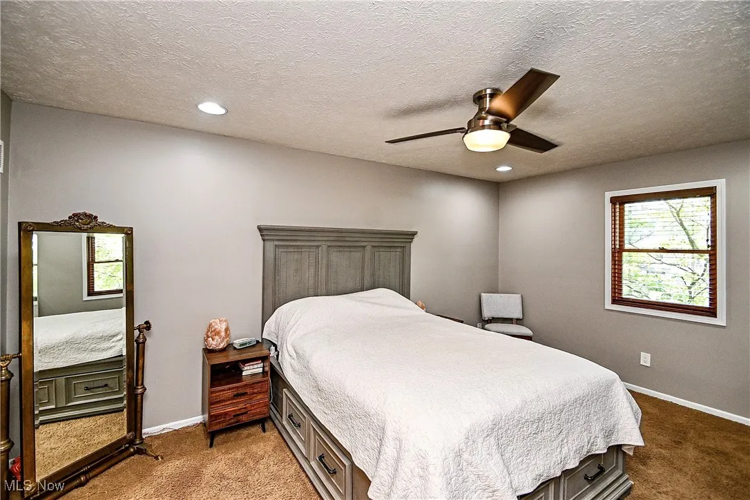 Bedroom with a textured ceiling, carpet flooring, a ceiling fan, and recessed lighting