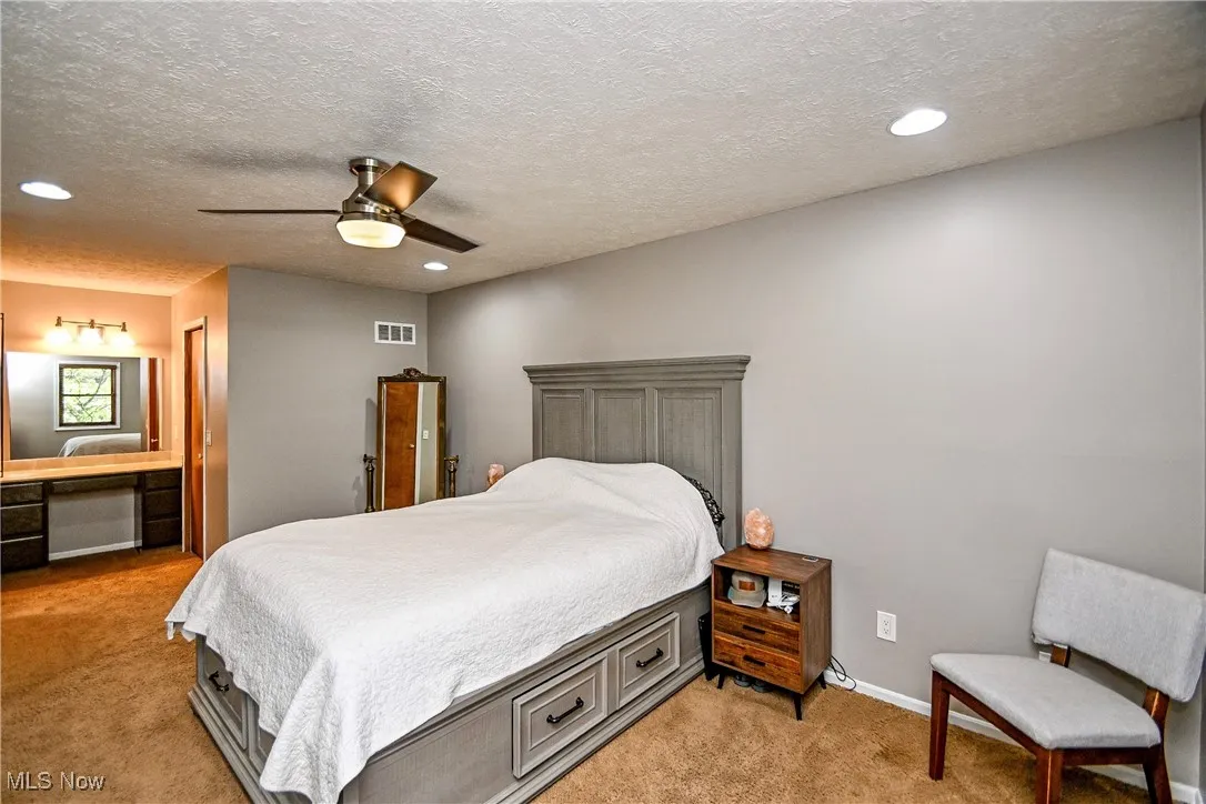 Bedroom featuring recessed lighting, light carpet, a textured ceiling, and a ceiling fan