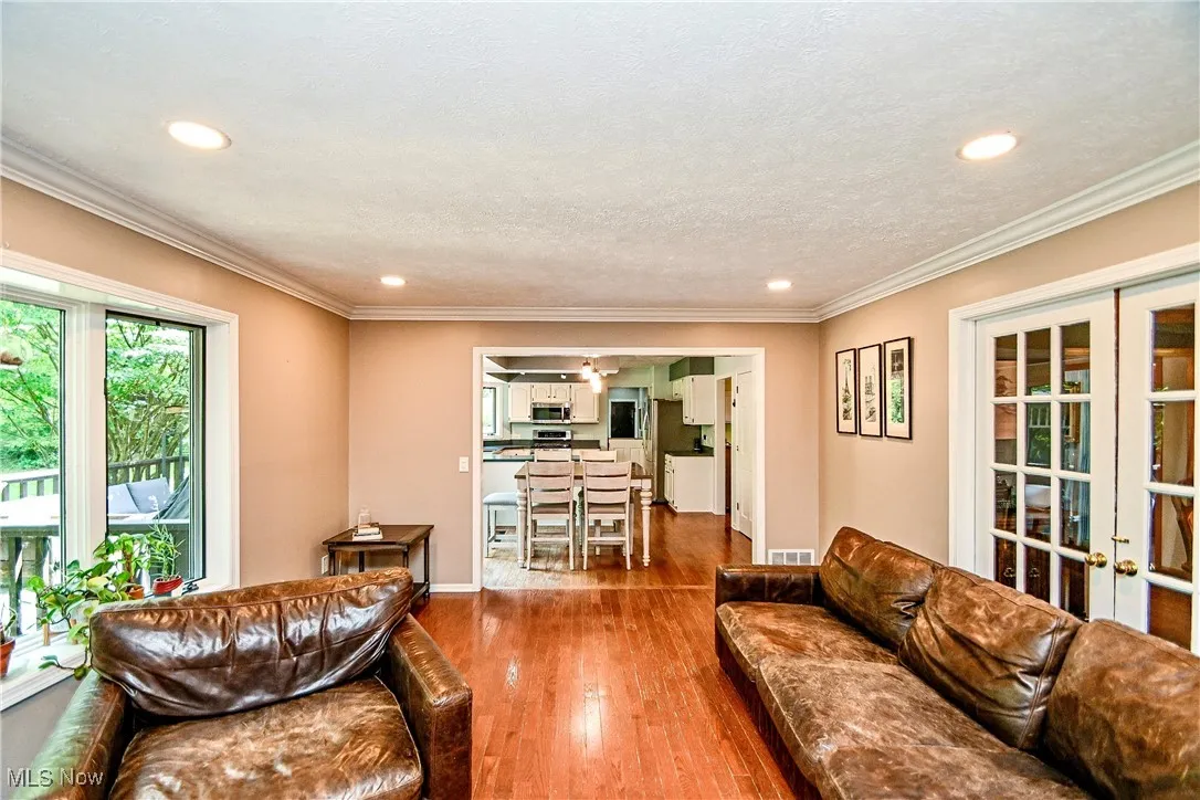Living room with recessed lighting, french doors, wood finished floors, and ornamental molding