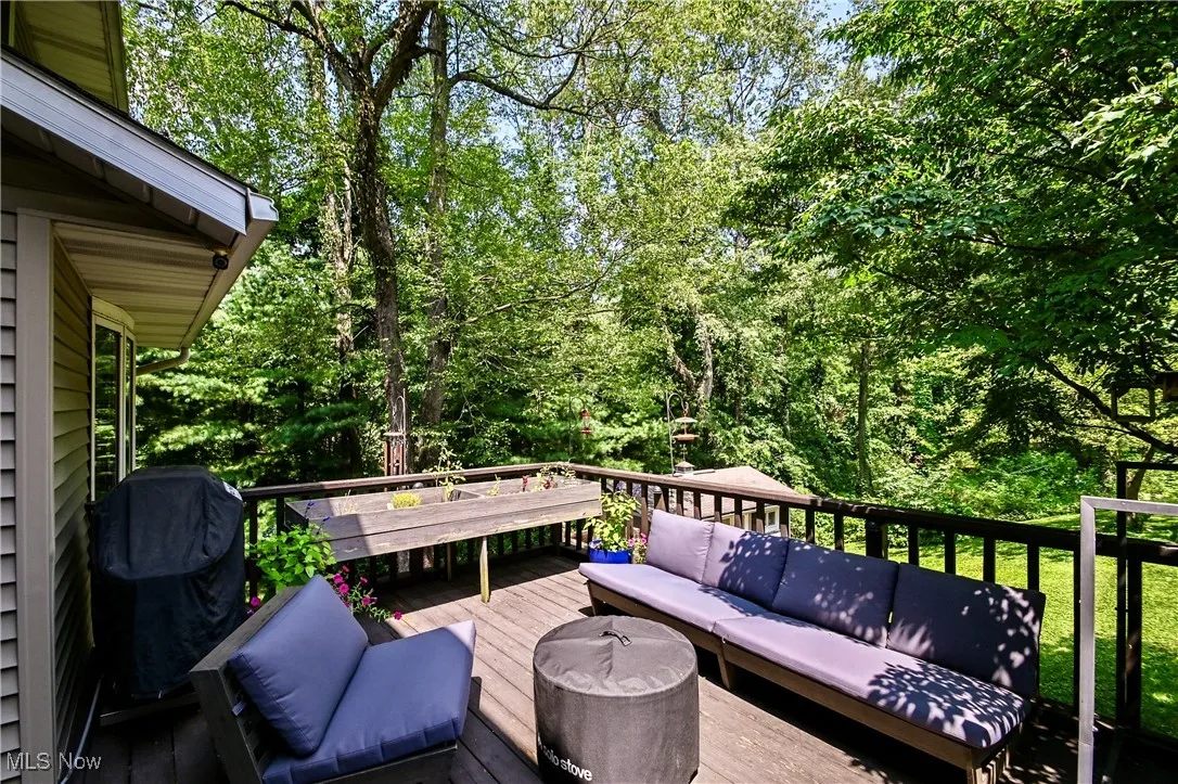 Wooden deck with an outdoor hangout area and area for grilling