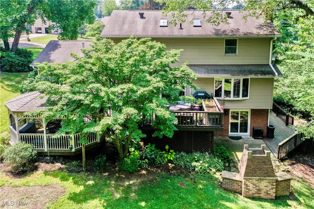Rear view of house featuring a deck and brick siding