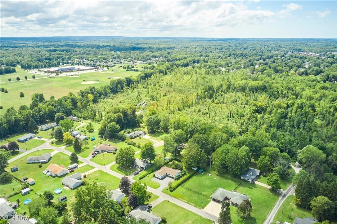 Aerial overview of property's location with a heavily wooded area