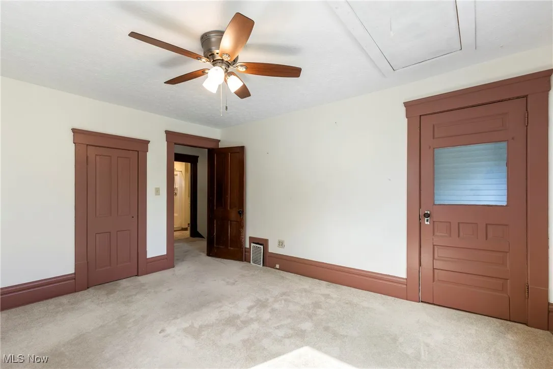 Bedroom at front of home with access to attic via pull-down stairs