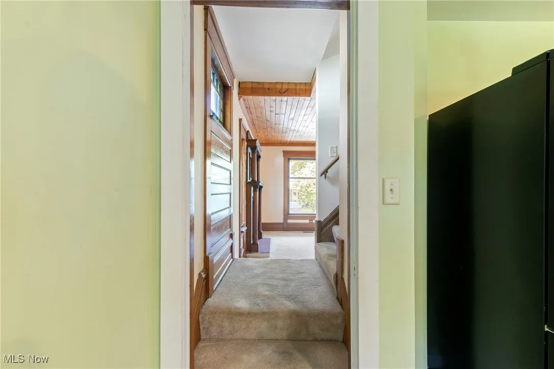 Looking from kitchen across landing into living room and to stairs leading up
