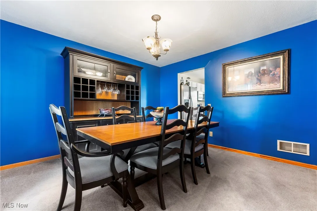 Dining room featuring a chandelier and light carpet