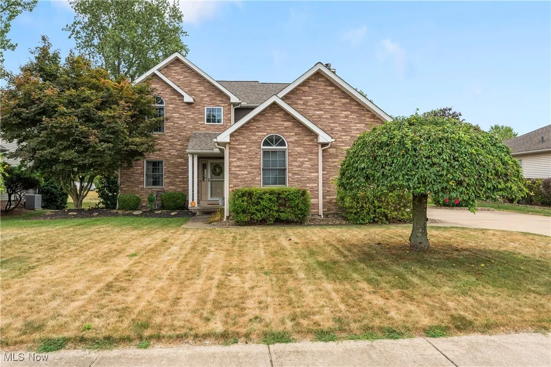 View of front facade featuring a front lawn and brick siding