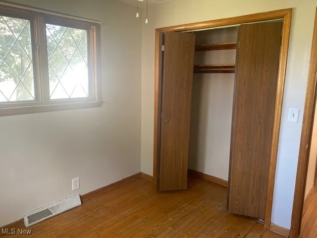 Unfurnished bedroom featuring light wood-style floors and a closet