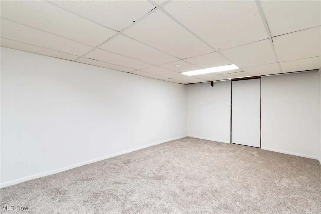 Finished below grade area with light carpet and a drop ceiling