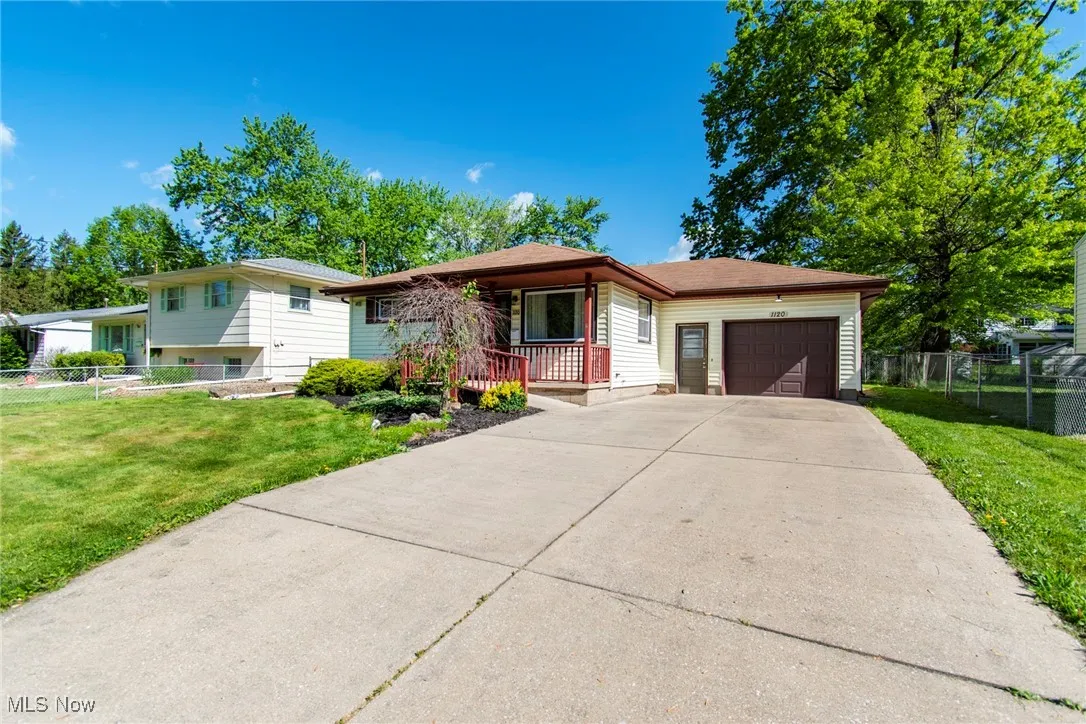 View of front facade featuring an attached garage, concrete driveway, and a porch