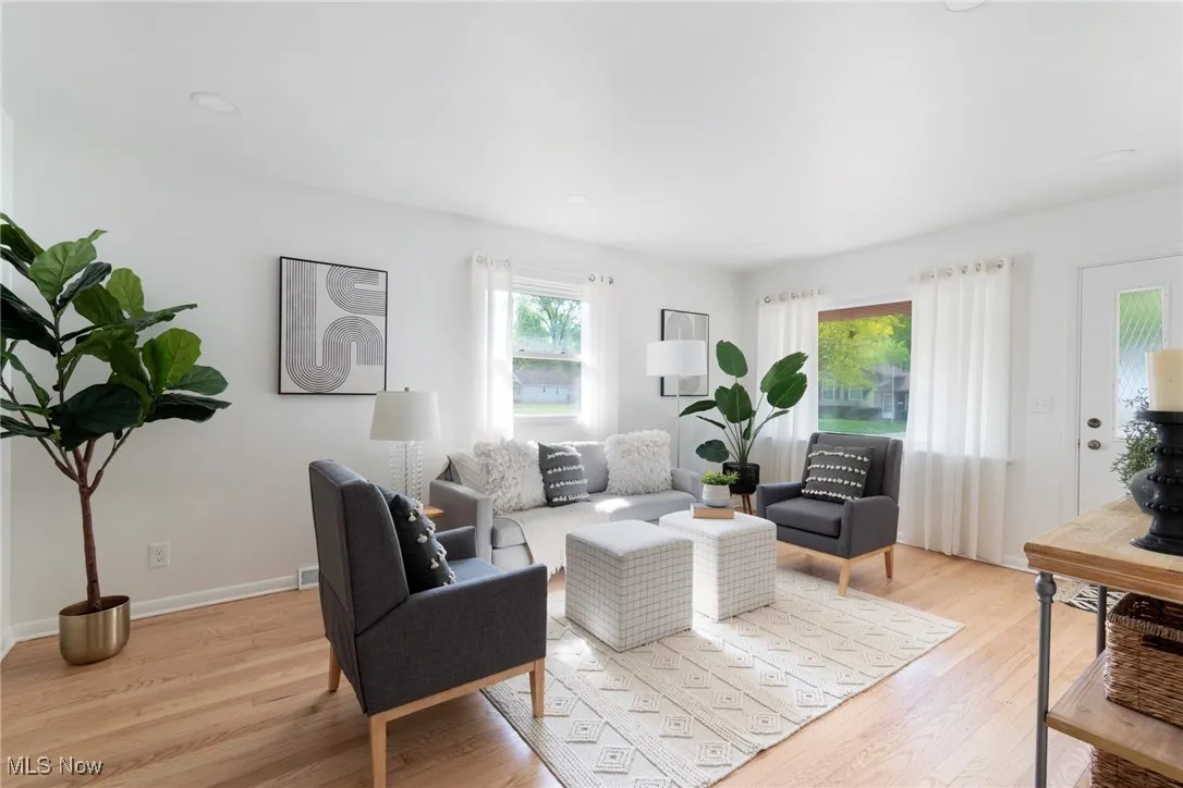 Living area with light wood finished floors and recessed lighting