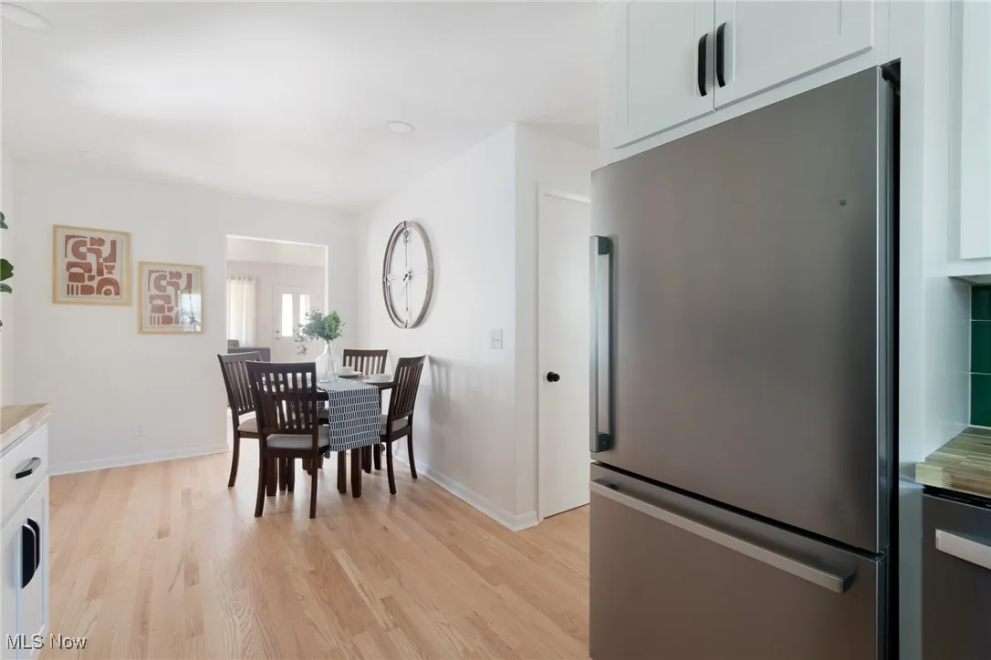 Dining space with light wood finished floors and recessed lighting