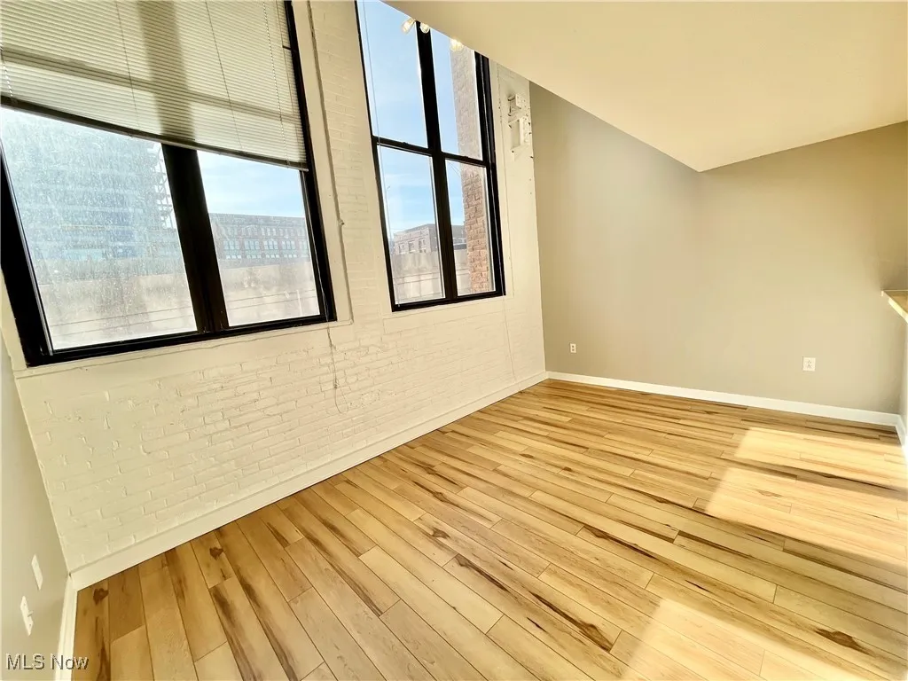 Living room with brick wall and light wood finished floors