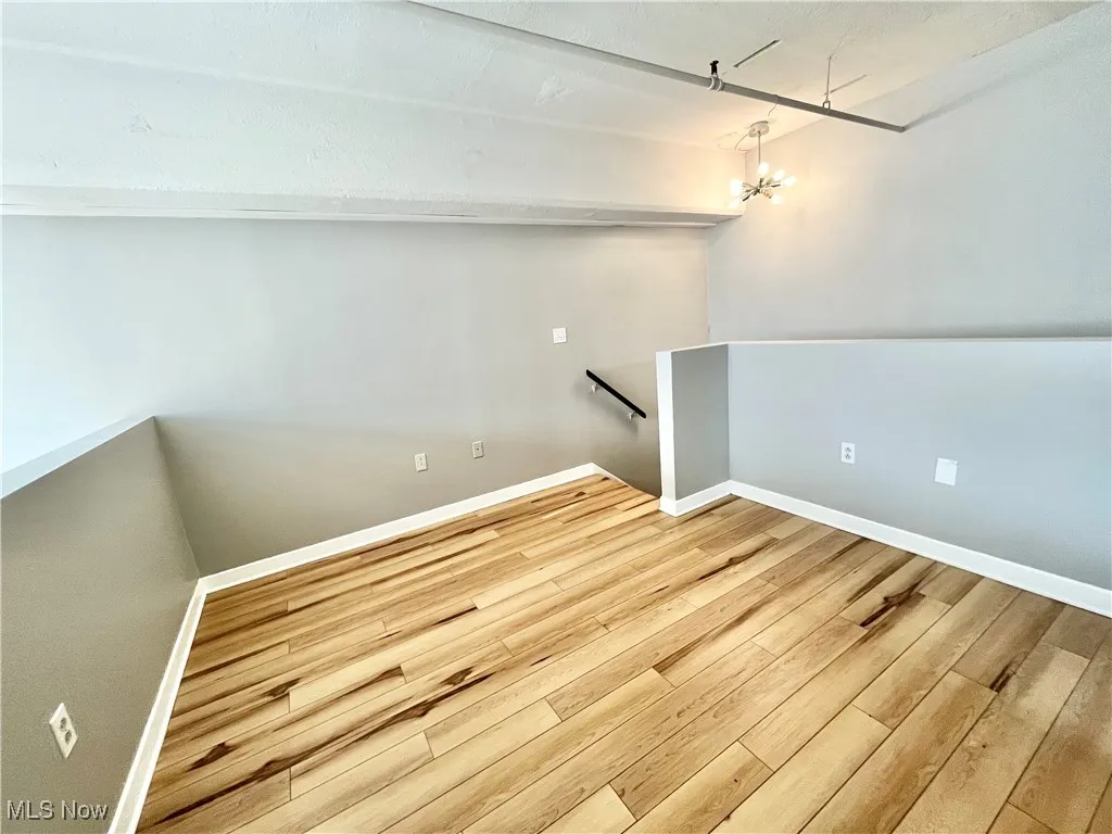 Bedroom featuring a chandelier and wood finished floors