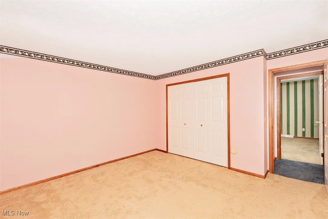 Unfurnished bedroom featuring a closet and carpet
