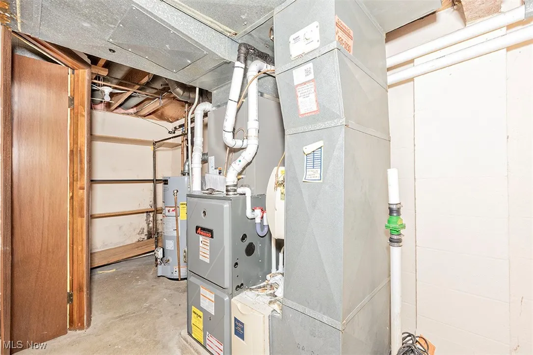 Utility room featuring heating unit and water heater