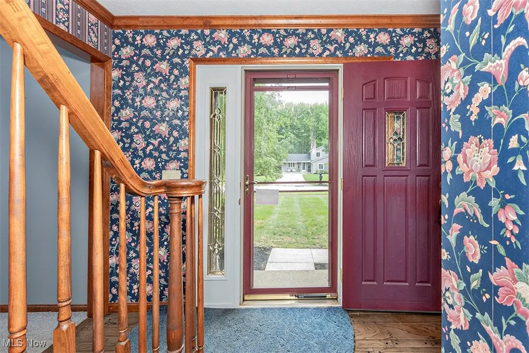 Foyer with stairs and wallpapered walls
