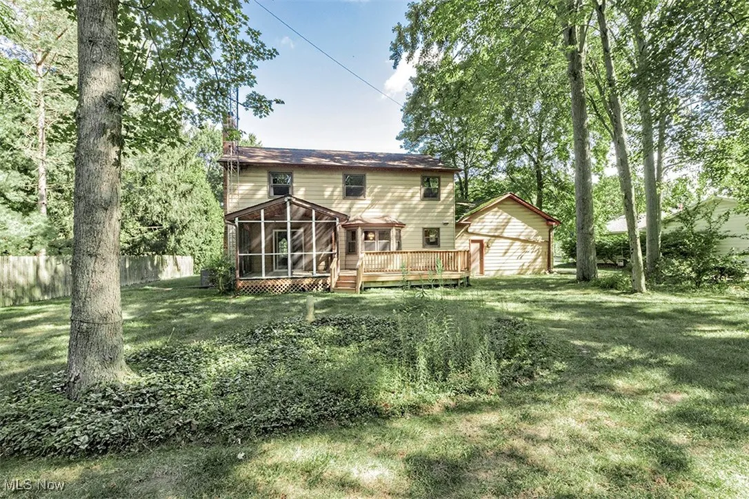 Rear view of property with a sunroom and a wooden deck