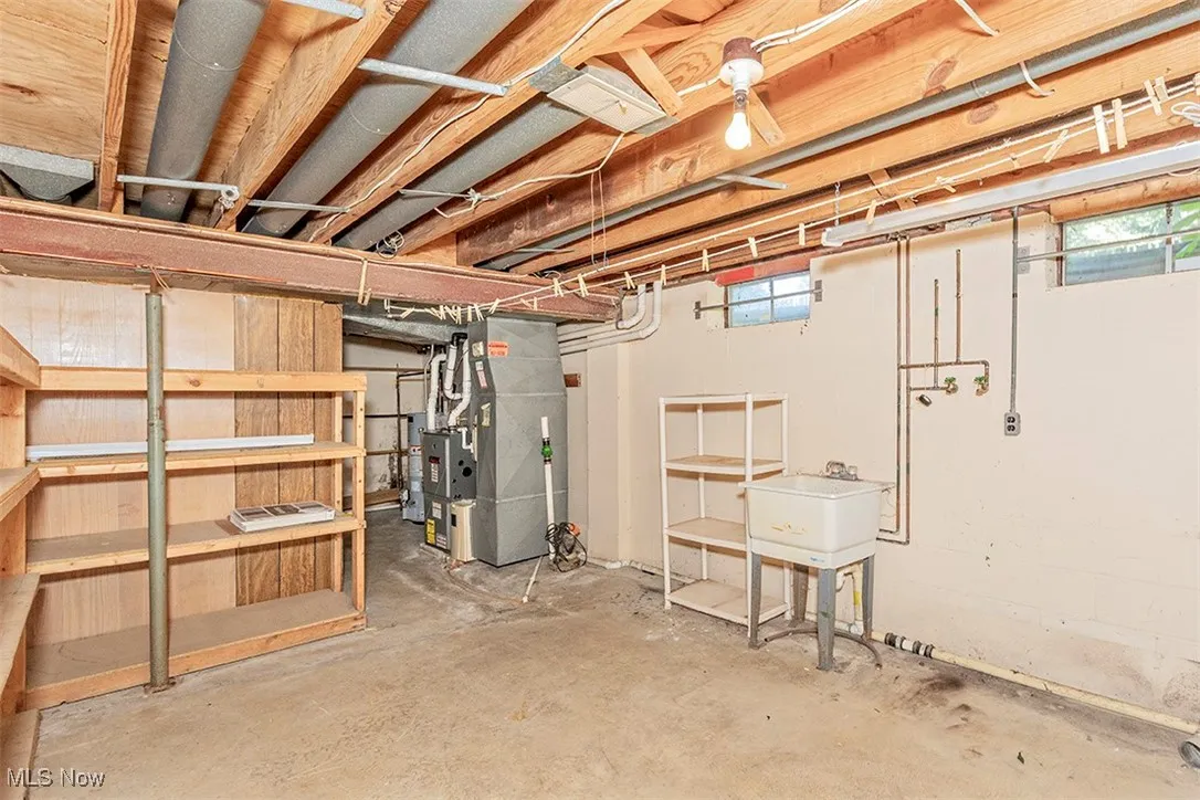 Below grade area featuring heating unit and water heater