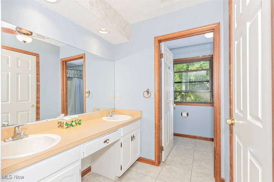 Full bathroom featuring double vanity, light tile patterned floors, recessed lighting, and a shower with shower curtain