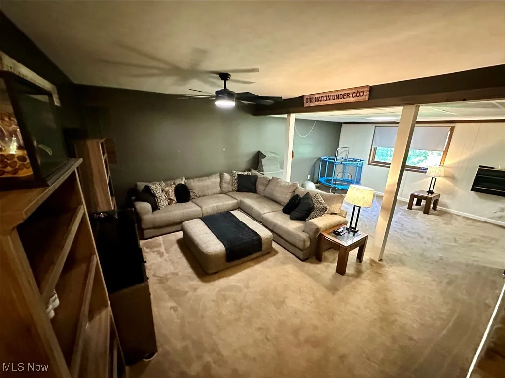 Carpeted living room with ceiling fan