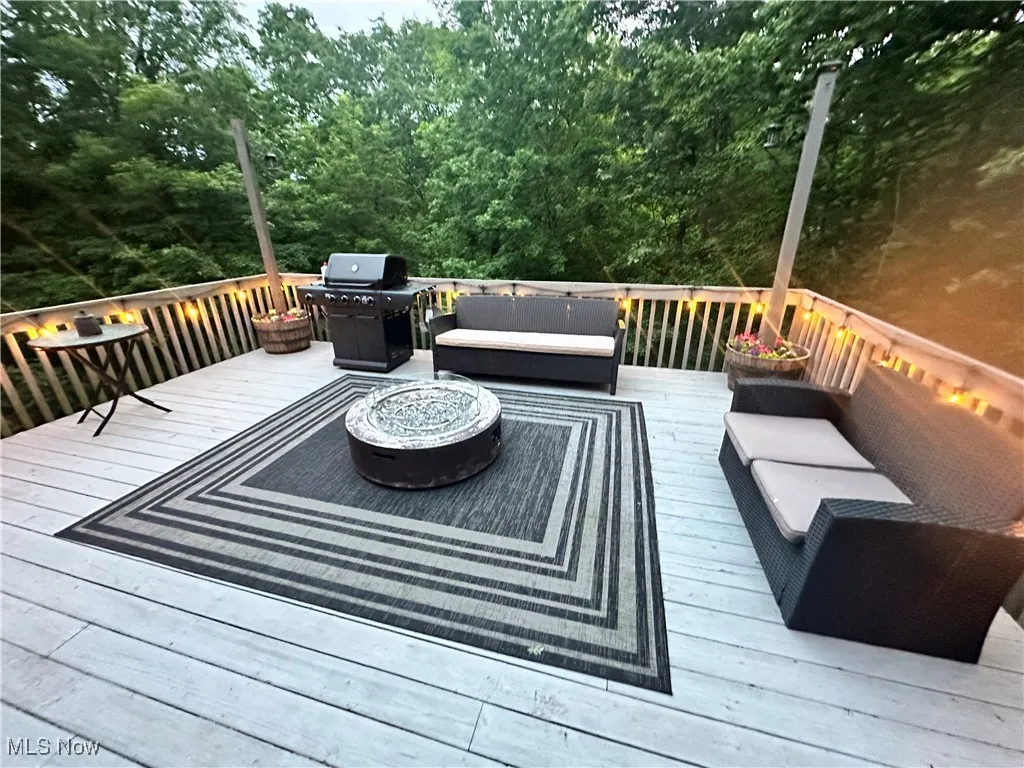 Wooden terrace featuring an outdoor living space and grilling area