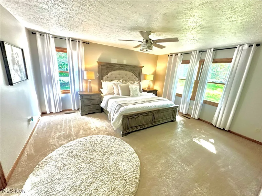 Bedroom featuring a ceiling fan and a textured ceiling