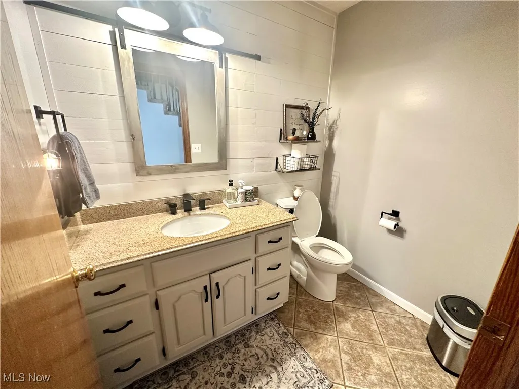 Half bath featuring vanity and light tile patterned floors